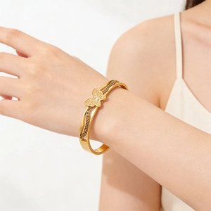 Eleganter goldener Schmetterlingsarmreif mit griechischem Muster am Handgelenk