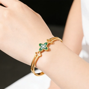 Detailed view of a gold clover bracelet with green malachite texture and small diamonds