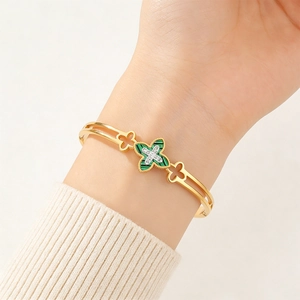 Detail of gold titanium clover bracelet with green malachite inlay and sparkling crystals