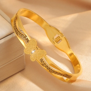 Detail eines goldenen Schmetterlingsarmbands mit griechischem Muster auf Seide