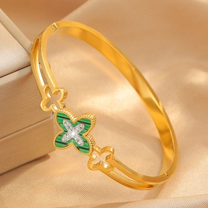 Macro shot of gold four-leaf clover bracelet with green malachite inlay and tiny diamonds