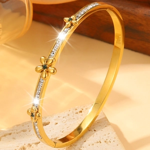 Gold stainless steel floral bangle with single row diamonds and green gemstones