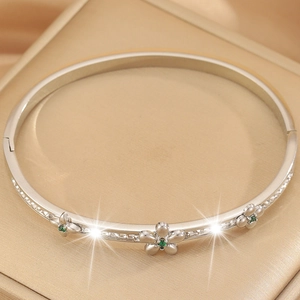 Detailed shot of silver floral bracelet featuring green zircon centers and diamond accents