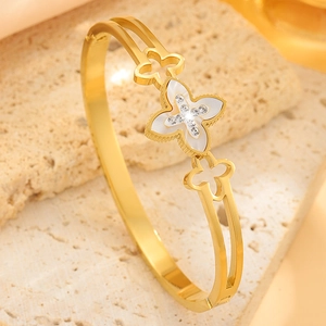 Detailed close-up of clover bangle with white shell inlay and sparkling crystals