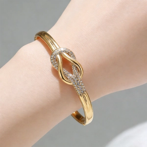 Detalle del brazalete de acero de titanio chapado en oro 18k con nudo de diamantes