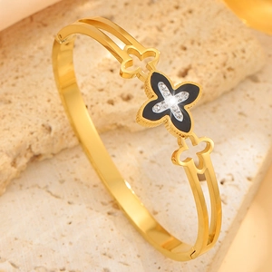 Detailed close-up of a gold-plated clover bangle with black enamel and zircon inlay