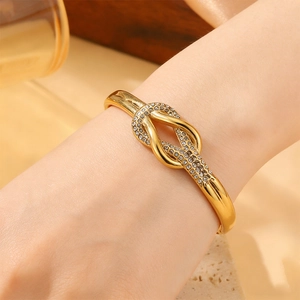 Detalle de la pulsera de acero inoxidable bañada en oro 18k con nudo de cristal