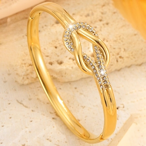 Elegante brazalete de nudo en acero inoxidable chapado en oro de 18k con circonitas claras