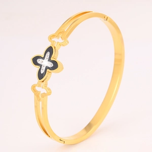 Detailed macro view of the gold hollow clover bracelet with embedded sparkling crystals