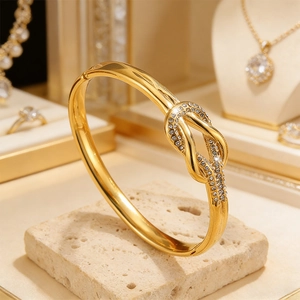 Elegante brazalete de nudo de acero inoxidable chapado en oro de 18k con pedrería