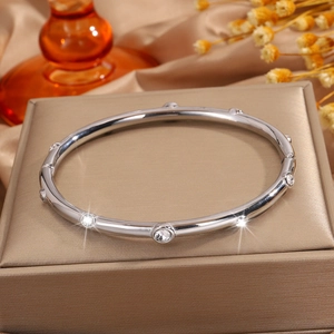 Vista detallada de un brazalete de acero inoxidable plateado con varios diamantes redondos