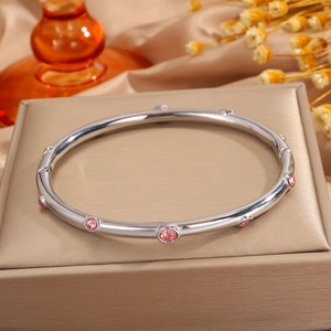 Detalle de cerca de una pulsera de acero inoxidable plateado con circonitas rosas