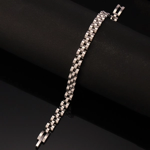 Close-up of a silver stainless steel three-row link bracelet on a black display stand