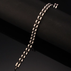 Macro shot of silver and black stainless steel three-link chain bracelet on display