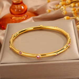 Detalle de brazalete bañado en oro 18k con diez cristales rosas en caja de regalo