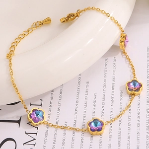 Vue détaillée d'un bracelet en titane doré avec breloques florales et fermoir mousqueton