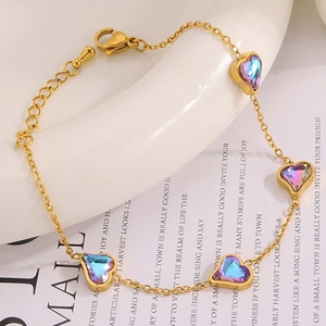 Détail d'un bracelet doré avec pendentifs cœurs et pierres précieuses opalescentes