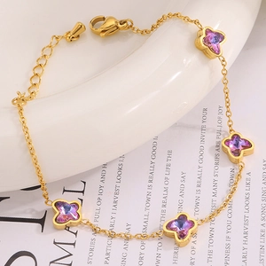 Détail d'un bracelet doré orné de pendentifs papillons violets dégradés avec fermoir mousqueton