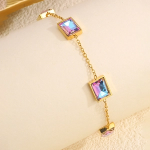 Détail du bracelet doré avec gemmes dégradées sur un présentoir à bijoux beige élégant