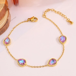 Détail d'un bracelet chaîne en or orné de pierres précieuses violettes irisées en goutte