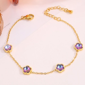 Détail du bracelet fleuri doré avec breloques en cristal violet et fermoir mousqueton