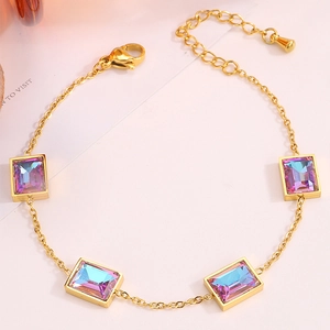 Détail du bracelet doré avec quatre cristaux violets rectangulaires et fermoir mousqueton