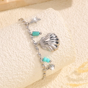 Détail du bracelet en acier titane argenté avec breloques coquillage et perles