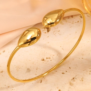 Λεπτομέρεια χρυσού ατσάλινου βραχιολιού με γυαλισμένα στοιχεία σε σχήμα σταγόνας νερού