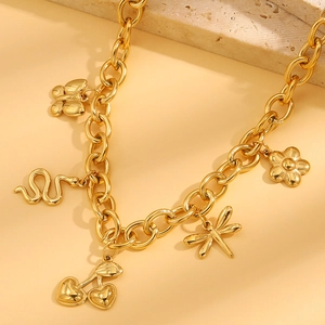 Nahaufnahme des goldfarbenen Charm-Armbands mit Schmetterling und Schlange auf dicker Kette