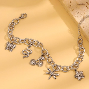 Nahaufnahme eines silbernen Bettelarmbands mit Schmetterling-, Schlangen- und Blumenanhänger