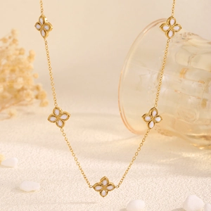 Collier élégant en acier titane doré avec cinq pendentifs trèfle blancs et bords perlés