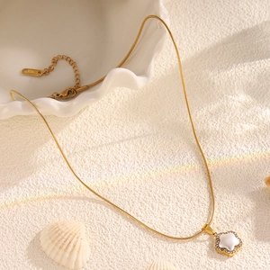 Détail du collier étoile en acier titane doré avec incrustation de perles et de cristaux