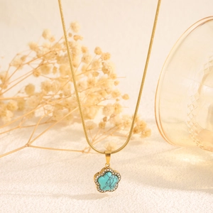 Détail du pendentif fleur avec turquoise et cristaux sur chaîne serpent dorée