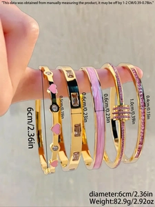 Détails de cinq bracelets dorés avec cœurs en émail rose et cristaux scintillants