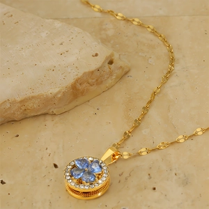 Detailed macro view of four-leaf clover necklace with blue heart crystals and gold plating