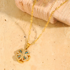 Detail of golden clover necklace featuring blue cat-eye stone and zircon micro-pave
