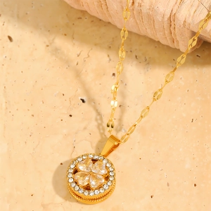 Detailed macro view of gold four-leaf clover pendant with yellow heart stones and crystals