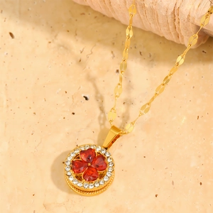 Close-up of gold titanium necklace with red heart clover pendant and crystals