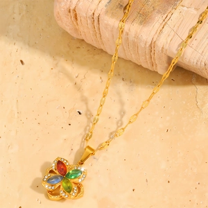 Dettaglio macro del ciondolo a fiore rotante dorato con cristalli colorati e strass