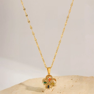 Detail of clover pendant with colorful gems and zircon stones on a gold necklace