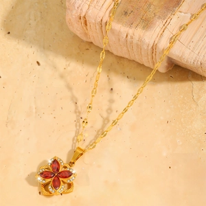 Collana a fiore rotante dorata con petali di gemme rosse e dettagli in zircone lucido