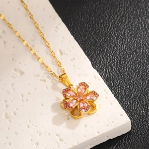 Detaillierte Makroansicht der rotierenden Goldblumenkette mit rosa Zirkonia-Steinen
