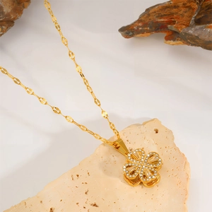Detailed macro view of gold four-leaf clover pendant with sparkling zircon inlays