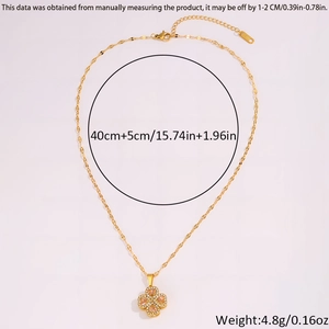 Detail of gold rotating four-leaf clover pendant with pink zircon and rhinestone accents