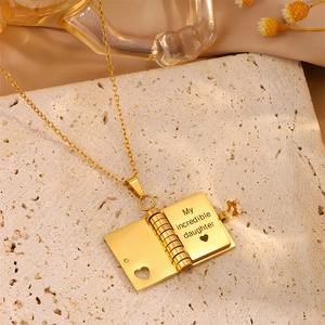 Detailed macro view of book-shaped golden locket showing internal daughter engraving