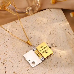 Macro detail of open book envelope pendant with engraved text for daughter in gold finish