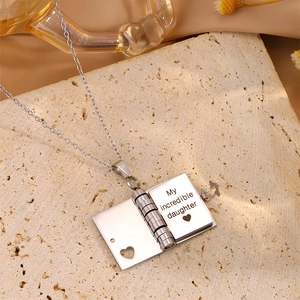 Macro detail of book-shaped pendant with My incredible daughter engraving