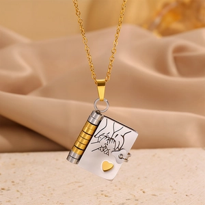 Book-shaped titanium steel envelope necklace with heart detail on a gold cable chain