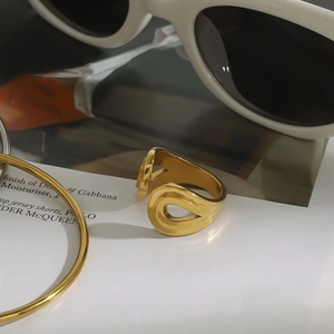 Vista detallada del anillo dorado con diseño fluido y moderno acabado metálico