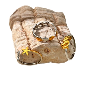Ensemble de trois bagues fleurs en acier avec breloques étoile de mer et cœur or et argent